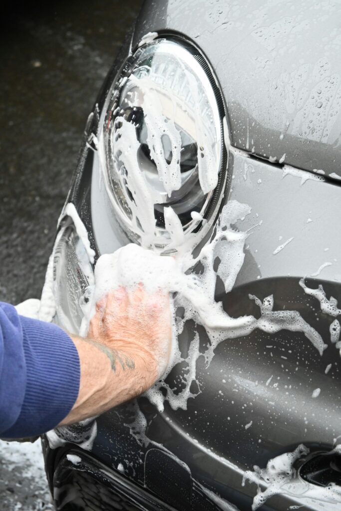 Vehicle in the RGV being thoroughly washed and covered in car soap during a professional auto detailing session, ensuring a spotless, protected finish.